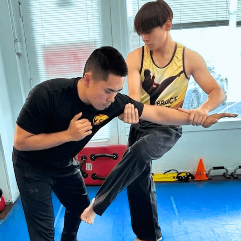 Photo a Combat Corner brand ambassador and MMA athlete coaching a student during a training session