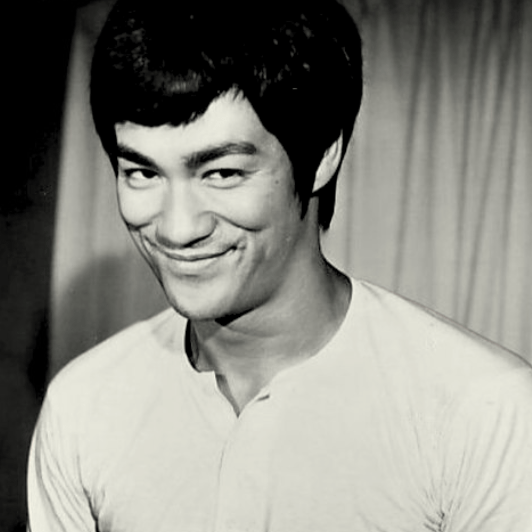 A black and white portrait photo of Bruce Lee