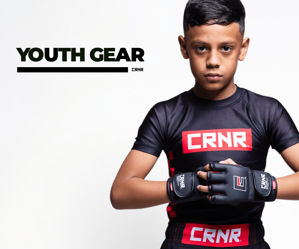 Photo a youth athlete wearing Combat Corner Youth and Kids Gear. The boy is wearing Combat Corner Youth Rash Guard, MMA Spar Gloves, and Fight Shorts.